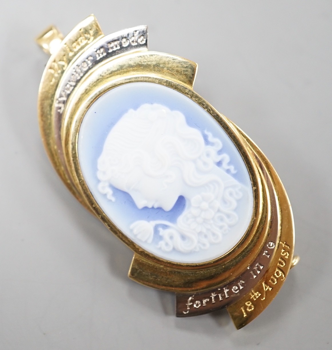 A modern two colour yellow metal and Wedgwood style cameo set oval pendant clip brooch, carved with the bust of a lady to dexter, the mount with engraved inscription, 'My Lady Sauviter In Modo Fortiter In Re 18th August'